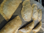 Photo of empanadas on baking sheet with parchment paper lining